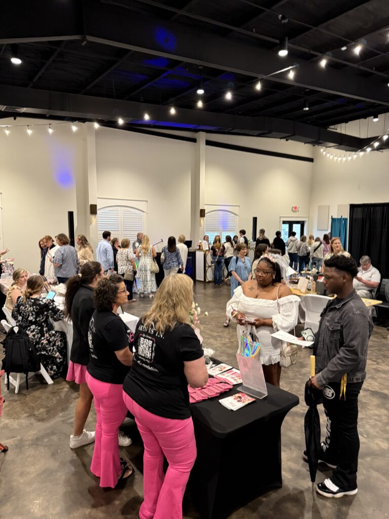 vendors set up with a bride and groom talking with a booth at Brides by the Bay in Daphne, AL